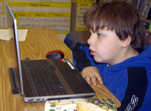 A young student uses a laptop computer.